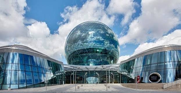 The Nur Alem sphere and AIFC campus buildings under a blue sky